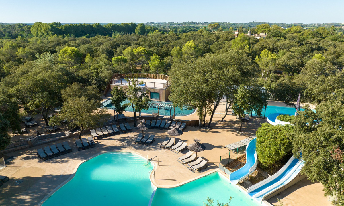 Pools with slides and sun loungers surrounded by trees at Marvilla Parks Le Domaine de Massereau